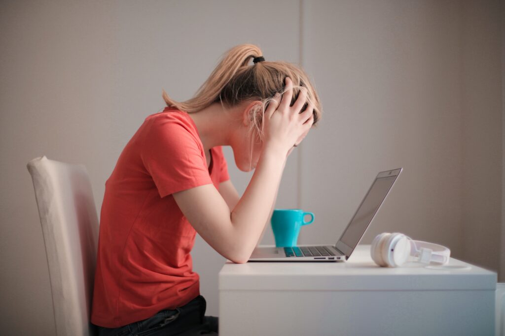 Woman looking at laptop stressed